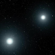 An illustration depicts two luminous blue-white dots, white dwarfs in pace set to merge.